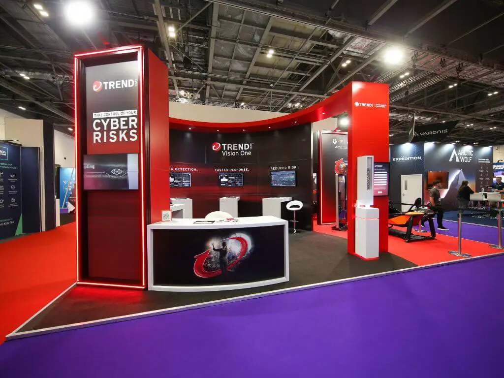 A curved custom exhibition stand for Trend Micro at the Infosec event, featuring bold red stand elements, digital screens, and seating areas.